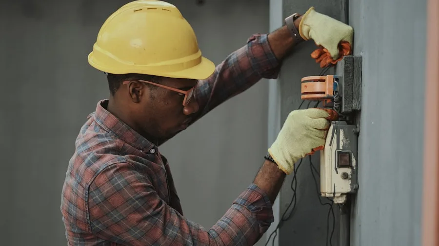 An electrician in a hard hat servicing an exterior electric meter